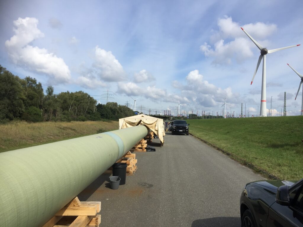 TDC GRP pau wrap FJC product being applied on a large diameter pipeline next to wind farm